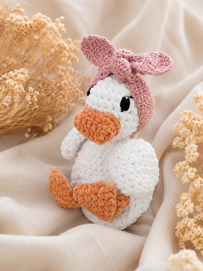 Knuffel eendje met oud roze haarbandje