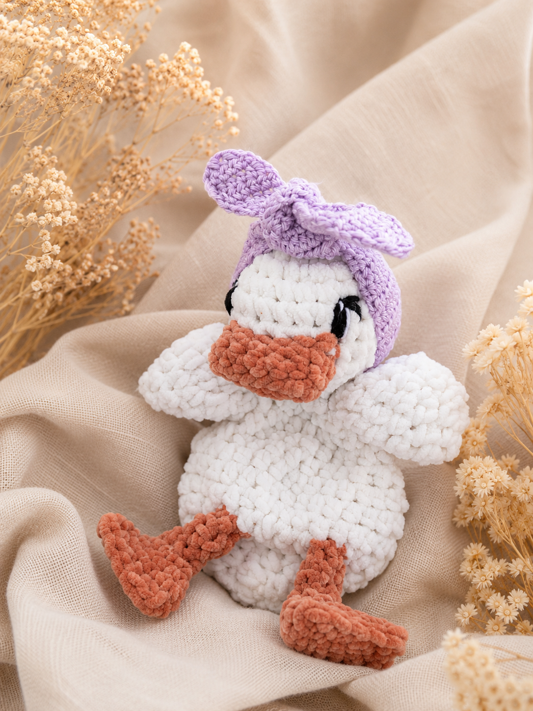 Knuffel eendje met lila haarbandje
