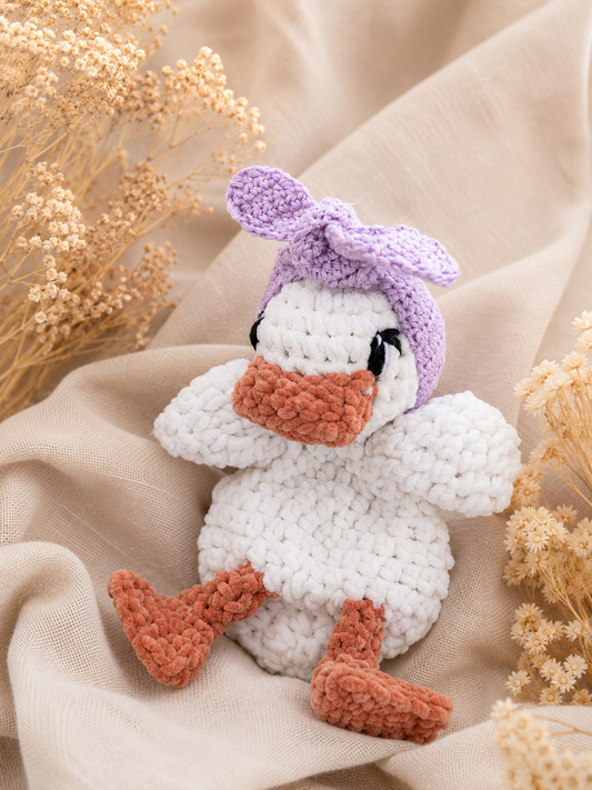 Knuffel eendje met lila haarbandje